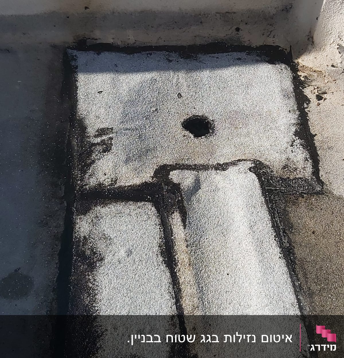 אזור אטום עם חומר איטום שחור על גג בטון